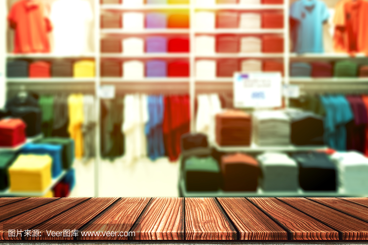 木制的桌子与模糊的背景休闲精品店,衬衫品牌outlet或彩色服装店的产品展示蒙太奇。以时尚产品零售业务为网络营销背景。